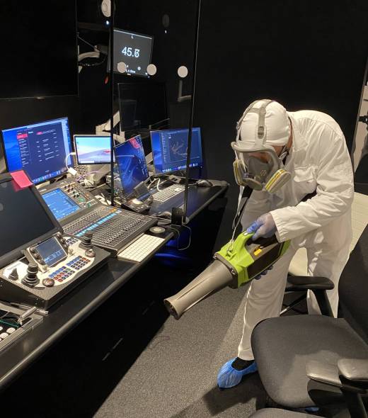 Certified disinfection technician using electrostatic fogging in a London broadcast control room, safe for IT and electronics